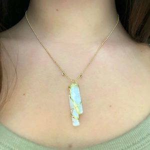 Gold necklace with crystal pendant.